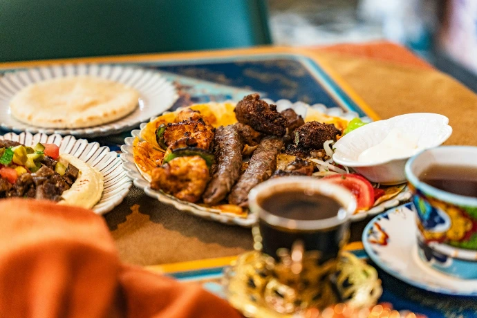 A platter of grilled meats with rice and pita bread.
